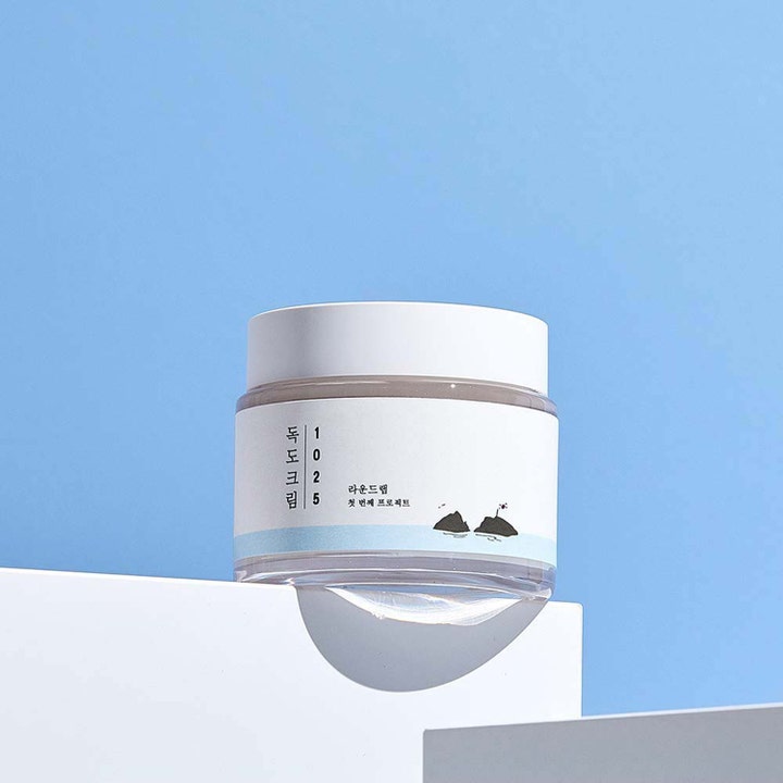 Round Lab 1025 Dokdo Cream 80 ml återfuktande ansiktskräm k-beauty i genomskinlig burk mot blå bakgrund