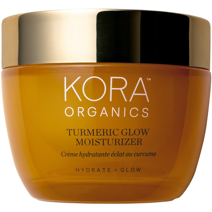 Kora Organics Turmeric Glow Moisturizer ger clean beauty glöd med gurkmeja hudvård i en bärnstensfärgad burk med guldlock.