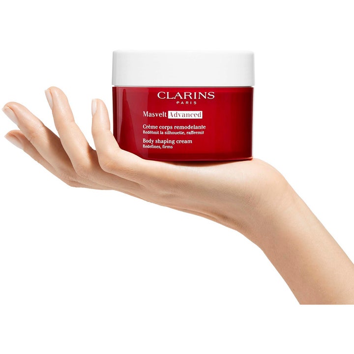Clarins Masvelt Advanced 200 ml uppstramande kräm för kroppen i röd burk som hålls i en hand.