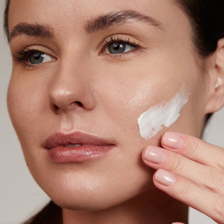 Verso N°8 Nourishing Mask 100 ml närande ansiktsmask med ceramider appliceras som en vit kräm på en kvinnas kind.