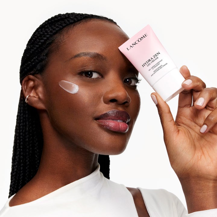 Lancôme Hydra Zen Moisturizing Gel Cream 30 ml återfuktande ansiktskräm i tub som hålls av en kvinna med kräm på kinden