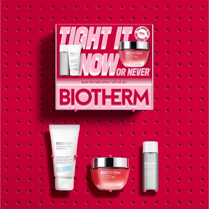 Biotherm Blue Peptides SPF30 Set hudvårdskit i rosa box med lyftande ansiktskräm och rengöring på röd bakgrund.