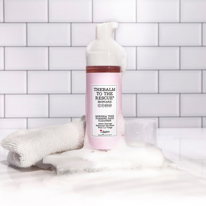 theBalm to the Rescue Moringa Tree Foaming Face Cleanser 150 ml ansiktsrengöring i rosa flaska omgiven av vitt mjukt skum.