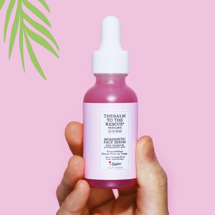 the Balm theBalm to the Rescue 30 ml återfuktande ansiktsserum med hyaluronsyra i en pipettflaska som hålls i en hand