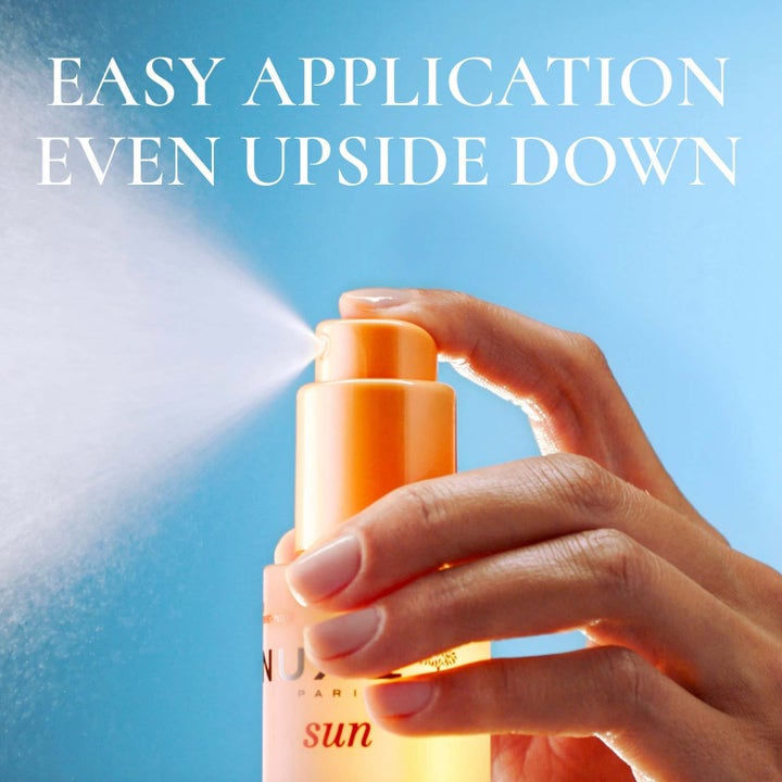 Nuxe Sun Mist Fresh Spf 30 150 ml solspray med texten Easy Application Even Upside Down när en hand sprayar misten.
