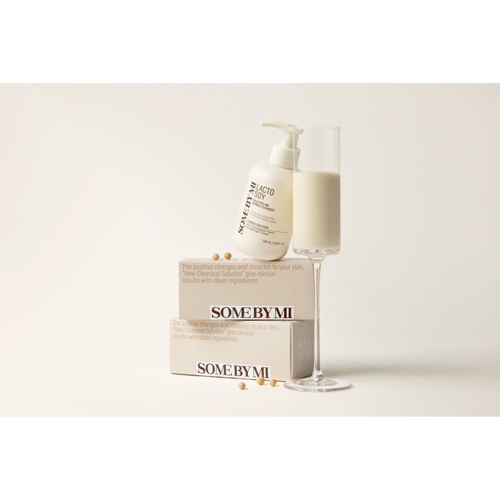 Some By Mi Lactosoy Mild Bubble Peeling Cleanser 180 ml aminosyra ansiktspeeling i pumpflaska intill ett glas sojamjölk.