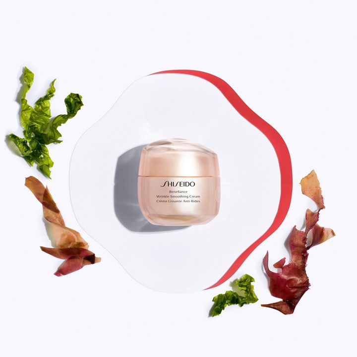 Shiseido Benefiance Wrinkle Smoothing Cream 50 ml rynkreducerande dagkräm i rosa burk omgiven av gröna alger.