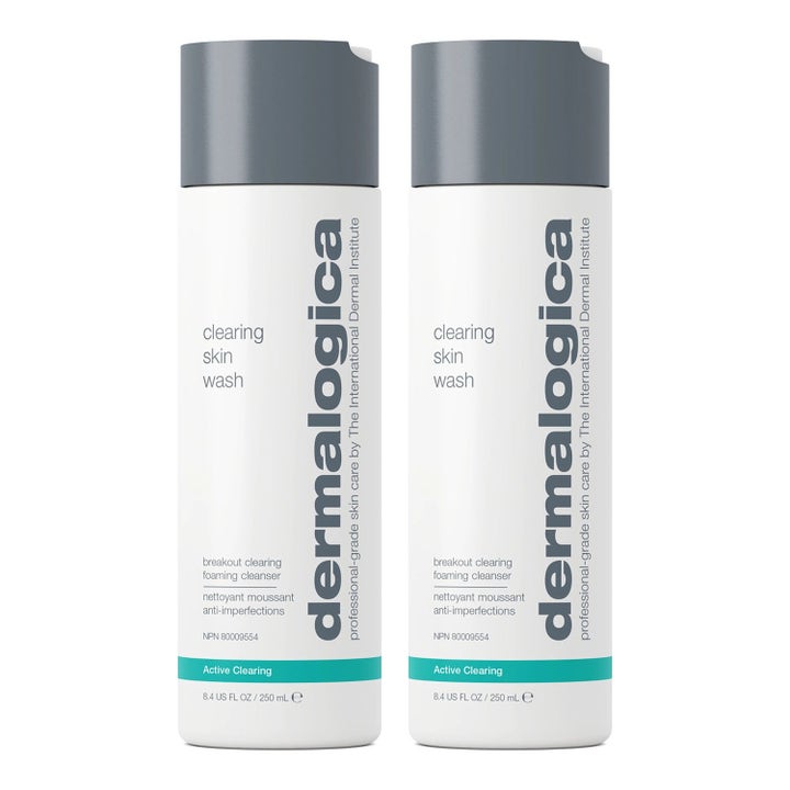 Dermalogica Clearing Skin Wash 250 ml lödderrengöring mot blemmor i två vita plastflaskor med grått lock och turkos rand.