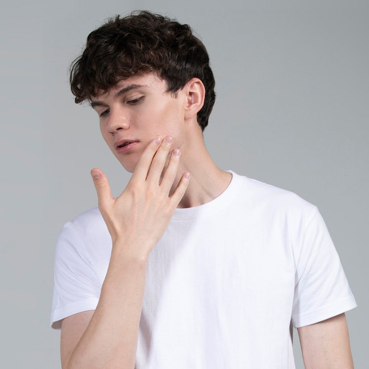 FOREO Blemish Solution 15 ml behandling mot acne som visas på en man som försiktigt rör vid sin kind.