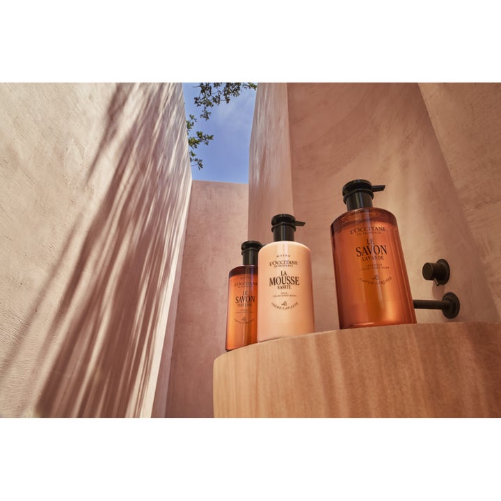 L'Occitane en Provence Shea Cream Hand Wash 500 ml krämig handtvål i beige pumpflaska i en varm arkitektonisk miljö.