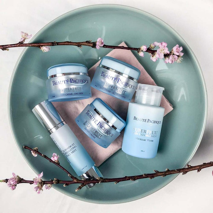Beauté Pacifique Superfruit Enforcement Day Cream 50 ml antioxidant återfuktande dagkräm i blå burk bland rosa blommor.
