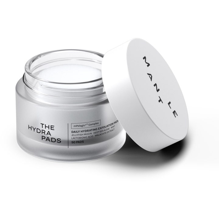 MANTLE The Hydra Pads 50 st återfuktande exfolieringspads i en öppen burk av frostat glas med vitt lock.