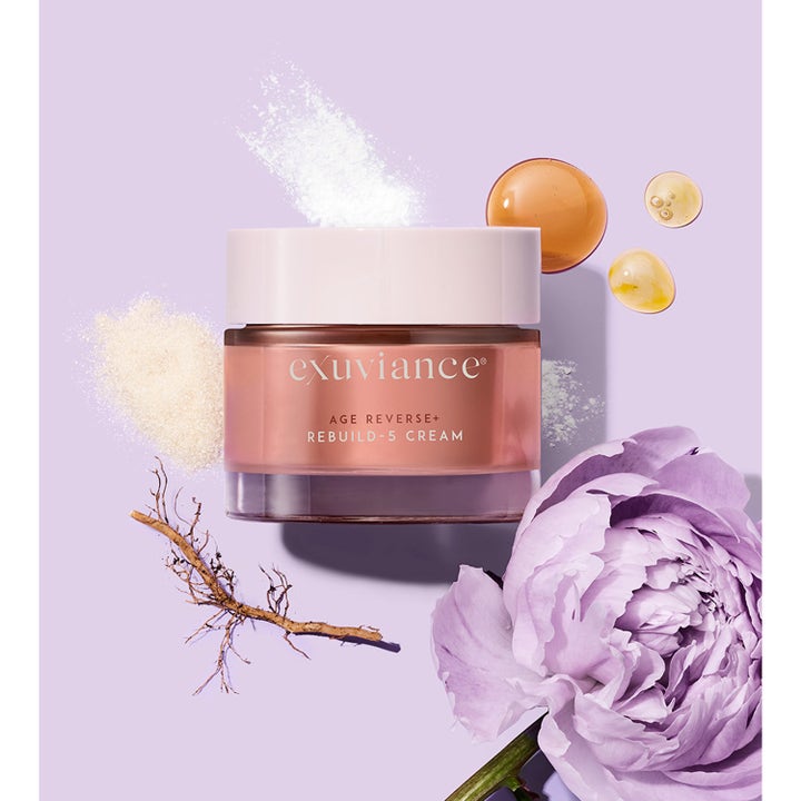 Exuviance Age Reverse + Rebuild-5 Cream 50 ml anti age dagkräm i roseguldfärgad burk omgiven av lila blomma och rötter