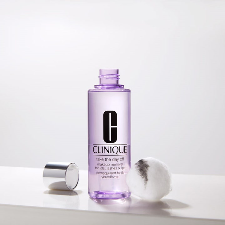 Clinique Take the Day Off 125 ml effektiv sminkborttagare i lila flaska med silverlock bredvid en bomullstuss.