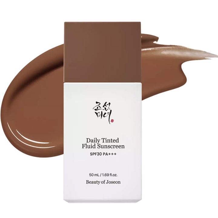 Beauty of Joseon Daily Tinted Fluid Sunscreen 50 ml ger SPF30 i vit flaska med mörkbrun flytande textur bakom.