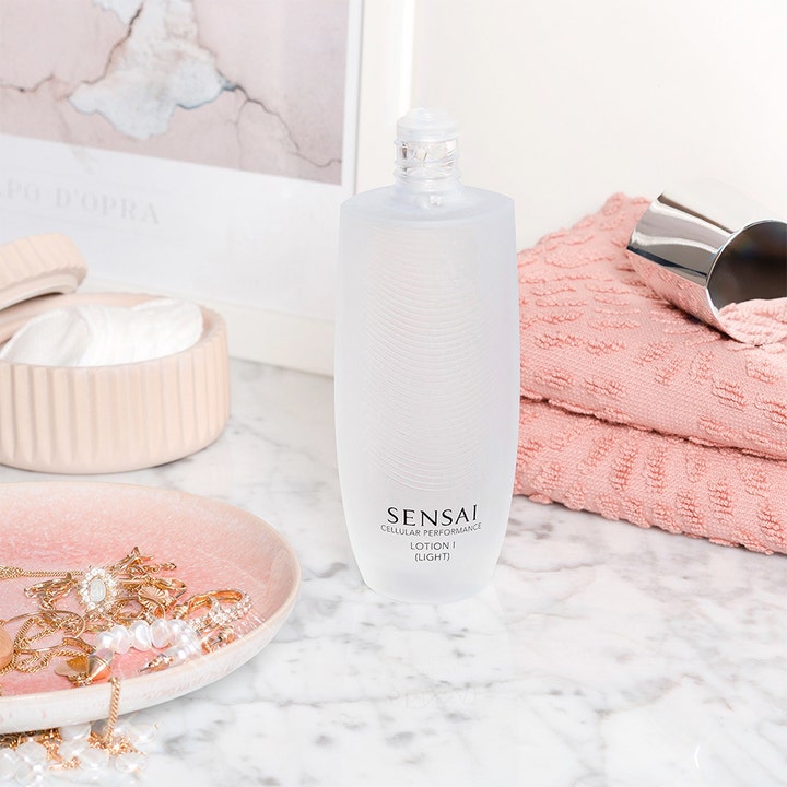 Sensai Cellular Performance Lotion I Light 125 ml japansk hudvård ansiktslotion i frostad flaska vid en rosa handduk