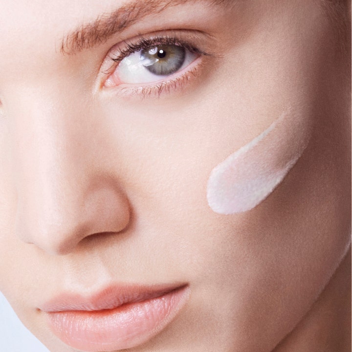 Lancôme UV Expert Supra Screen SPF 50 40 ml ger uv-skydd ansikte med en lätt krämig textur på en persons kind.