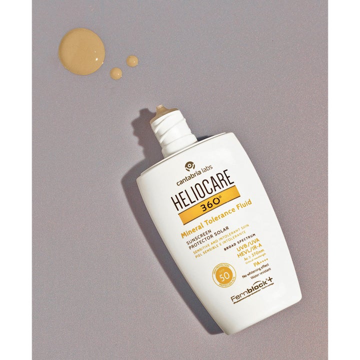 Heliocare Mineral Tolerance Fluid 50 ml ger bredspektrum solskydd känslig hud med ljust beige droppar bredvid flaskan