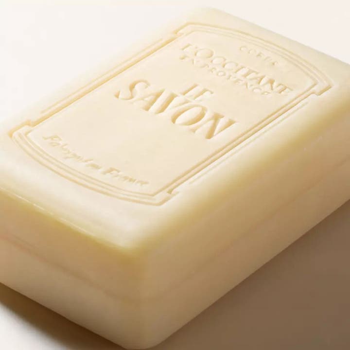 L'Occitane en Provence Extra Gentle Soap Lavender 250 g extra mild lavendeltvål som beige fast tvål med präglad logotyp.