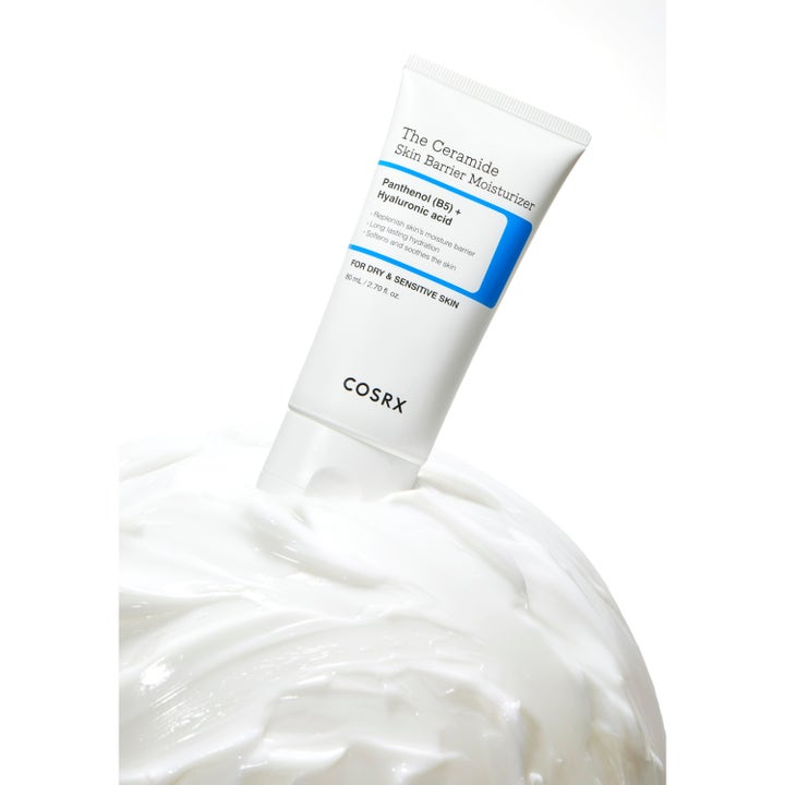 COSRX The Ceramide Skin Barrier Moisturizer 80 ml stärkande dagkräm i vit tub placerad i en fyllig krämig textur.