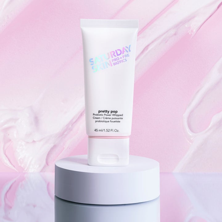 Saturday Skin Pretty Pop Probiotic Power Whipped Cream 45 ml återfuktande ansiktskräm i vit tub på ett podium.