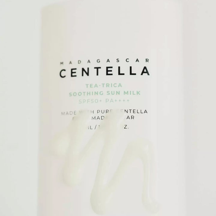 SKIN1004 Madagascar Centella Tea-Trica Soothing Sun Milk 50 ml i vit flaska med lätt krämig textur framför.