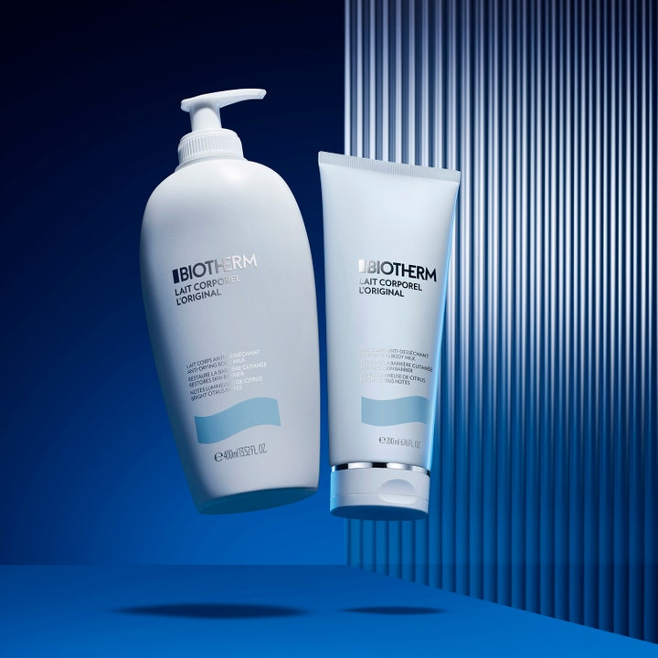 Biotherm Lait Corporel 200 ml återfuktande bodylotion i vit tub bredvid en pumpflaska mot blå bakgrund.