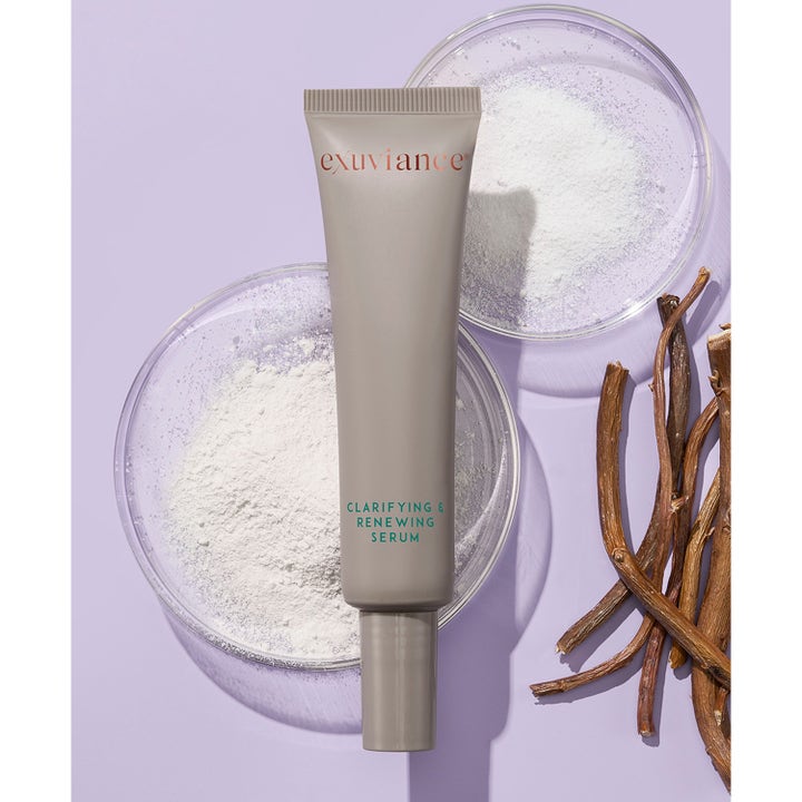 Exuviance Clarifying and Renewing Serum 30 ml exfolierande ansiktsserum i grå tub omgiven av vitt pulver och rötter