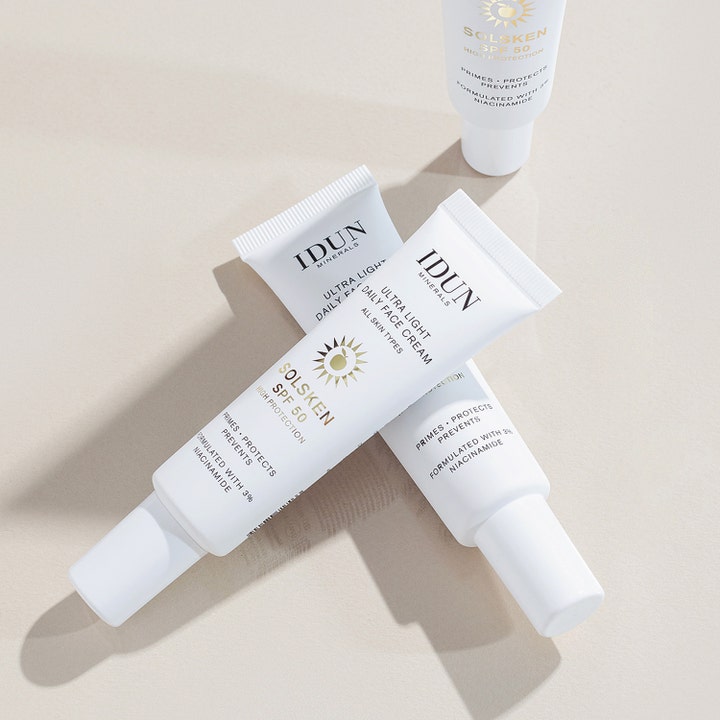 IDUN Minerals Solsken SPF50 30 ml solkräm för ansiktet med niacinamid i tre vita tuber mot en beige bakgrund.