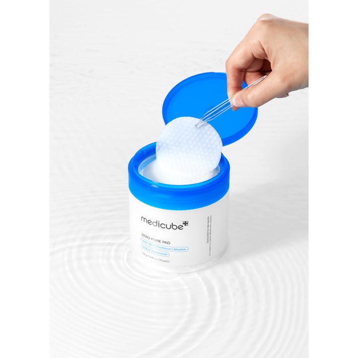 Medicube Zero Pore Pad 70 st exfolierande pads med AHA och BHA lyfts ur burk med pincett för renare porer.