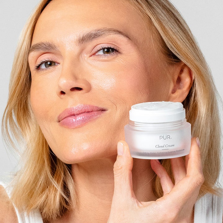 PÜR Cloud Cream 50 ml fuktgivande ansiktskräm i frostat glasburk hållen av en kvinna med lyster