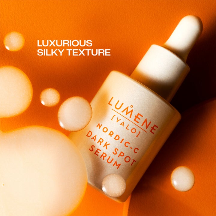 Lumene Dark Spot Serum 30 ml lystergivande serum mot mörka fläckar med silkeslen textur och droppar på orange bakgrund.
