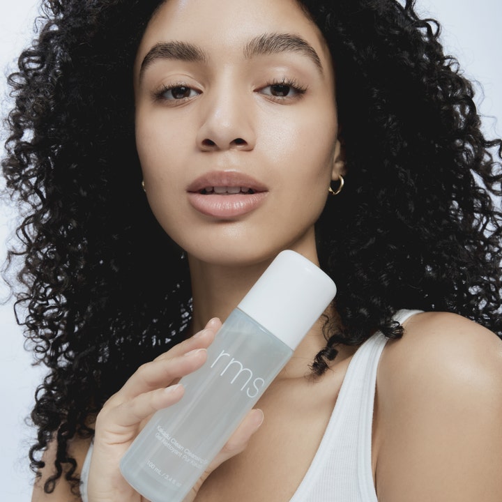 RMS Beauty Kakadu Clean Cleansing Gel 100 ml rengöringsgel i frostad flaska som hålls av en kvinna.