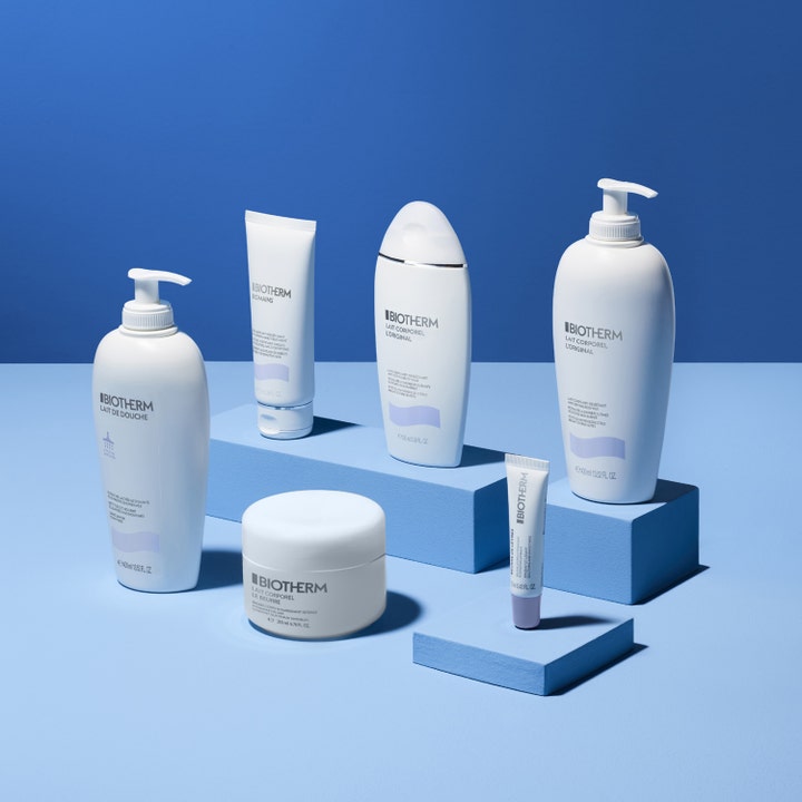 Biotherm Lait Corporel Moisturizing Shower Milk 200 ml återfuktande duschtvål i vit flaska på blå podier