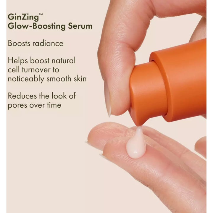 Origins GinZing Glow-Boosting Serum ger lyster genom en krämig droppe på ett finger från orange pumpflaska