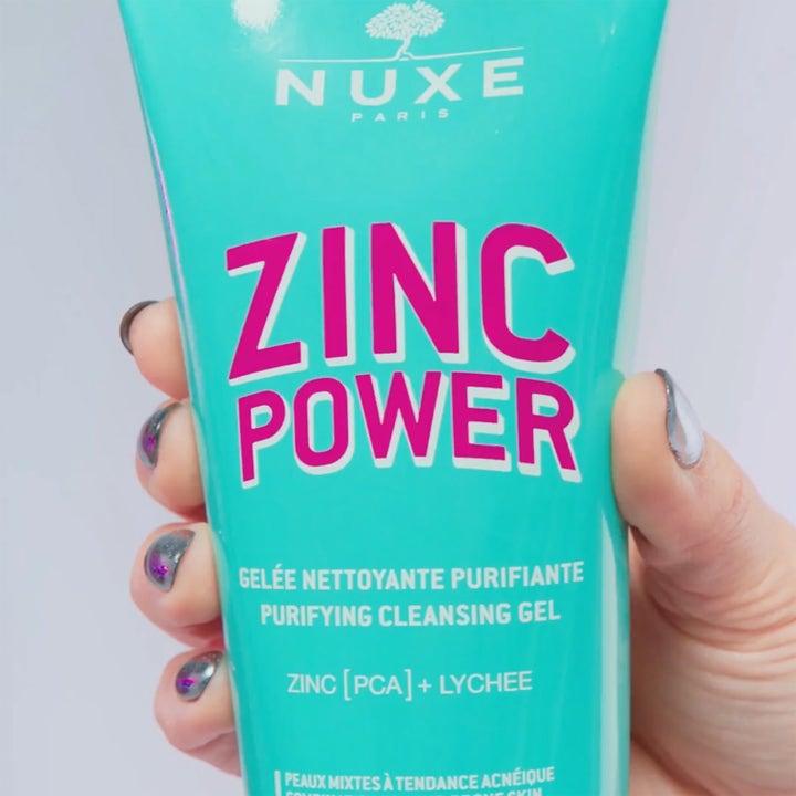 Nuxe Zinc Power Purifying Cleansing Gel 150 ml renande ansiktsrengöring i turkos tub med rosa text i en hand