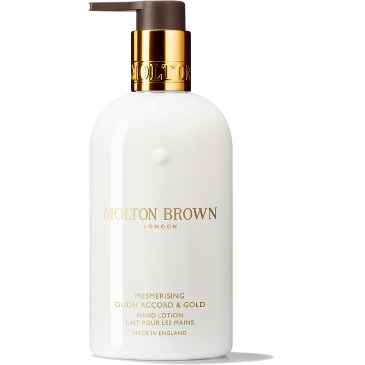 Molton Brown Mesmerising Oudh Accord & Gold exklusiv oud handkräm i vit flaska med guldpump för premium hudvård.