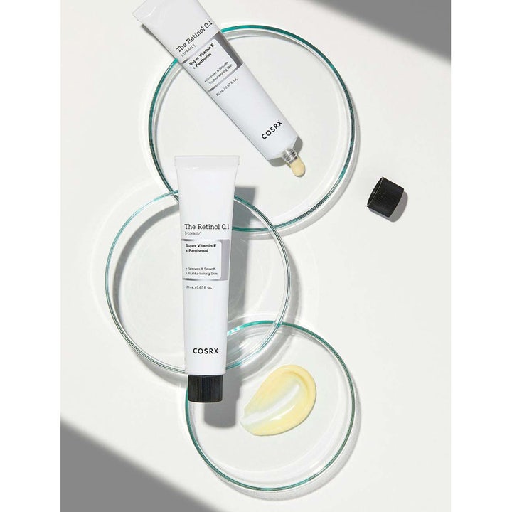 COSRX The Retinol 0.1 Cream 20 ml föryngrande ansiktskräm i vita tuber med gulaktig textur på petriskålar av glas