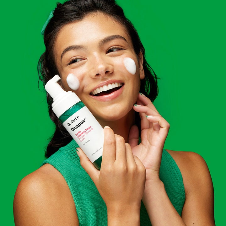 Dr.Jart+ Cicapair Gentle Cleansing Foam 150 ml mild ansiktsrengöring som används av en kvinna mot grön bakgrund
