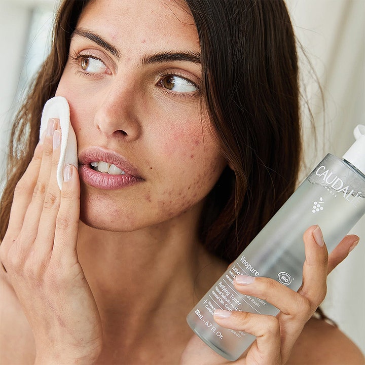 Caudalie Vinopure Purifying Toner 200 ml akne toner för ekologisk salicylsyra hudvård som appliceras med bomull.