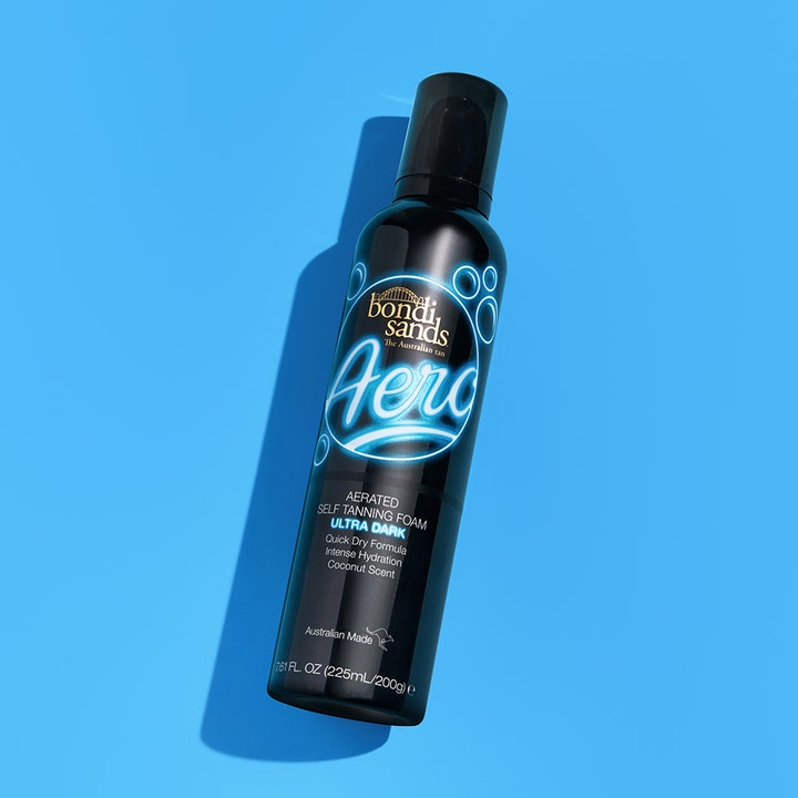 Bondi Sands Aero Self Tan Foam Ultra Dark 225 ml brun utan sol för intensiv färg i svart flaska mot blå bakgrund.