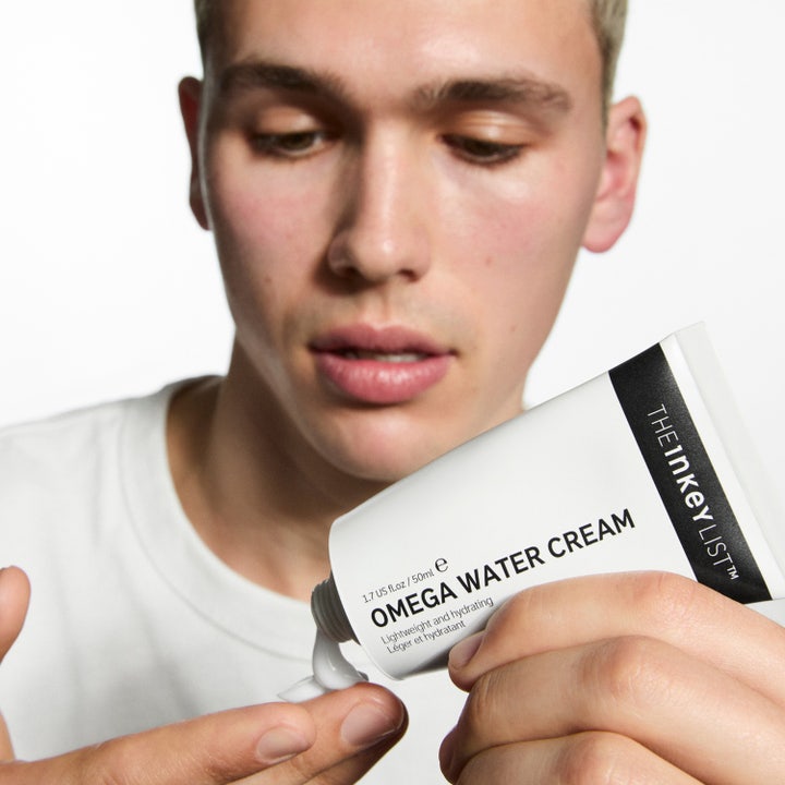 The INKEY List Omega Water Cream 50 ml fuktgivande vattenkräm som en man applicerar från en vit tub.