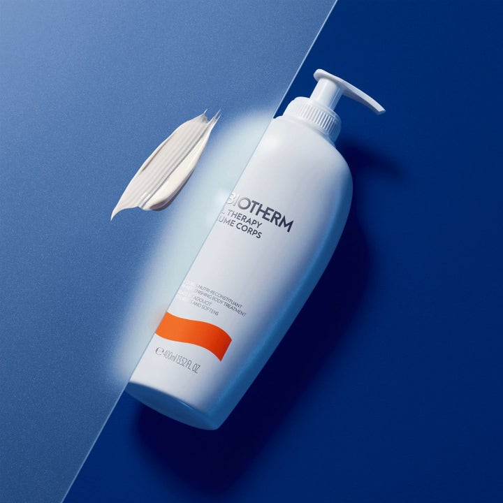 Biotherm återfuktande kroppskräm 400ml för torr hud med vit pumpflaska och en krämig textur på blå bakgrund