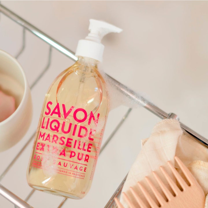 Compagnie de Provence Liquid Marseille Soap Wild Rose 495 ml handtvål pump rosdoft i klar flaska placerad i en trådkorg.
