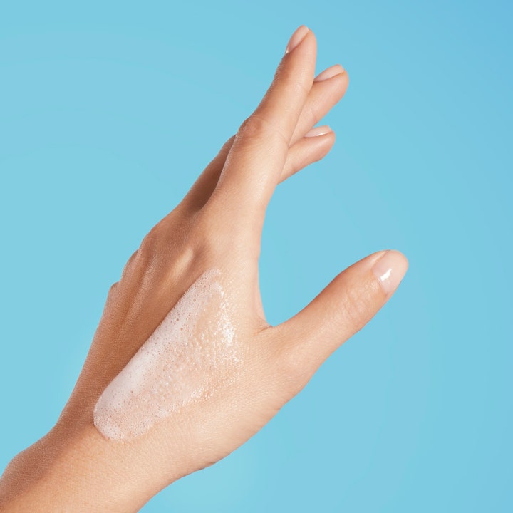 Biotherm Oil Therapy Baume Corps 200 ml duscholja för känslig torr hud med krämigt vitt skum applicerat på en hand.