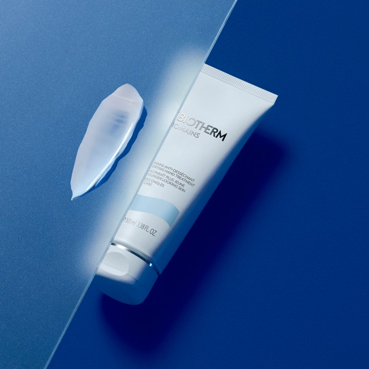 Biotherm Biomains 100 ml anti-åldrande handkräm i vit tub med en krämig klick bredvid på blå bakgrund