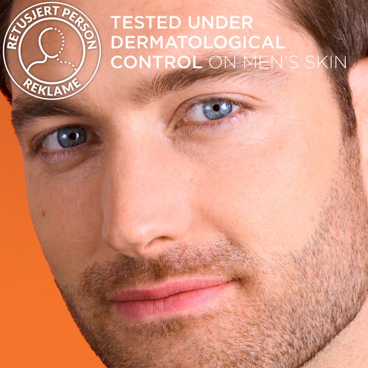 L'Oréal Paris Men Expert Vitamin C Serum 30 ml lystergivande hudvård för män på närbild av ansikte mot orange bakgrund