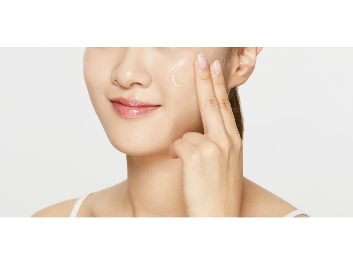 COSRX Ultimate Moisturizing Honey Overnight Mask 60 ml nattmask appliceras på kinden med fingertopparna.