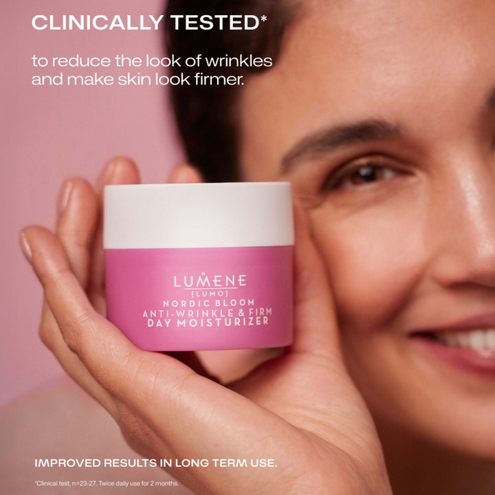 Lumene Nordic Bloom 50 ml rynkreducerande uppstramande kräm i rosa burk som hålls av en kvinna för fastare hud.
