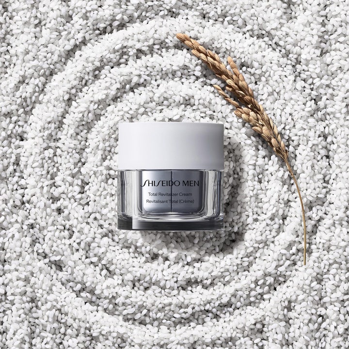 Shiseido Men Total Revitalizer Cream 30 ml revitaliserande dagkräm i grå burk placerad i en virvel av vitt ris